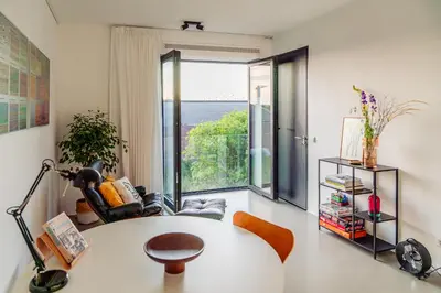 a living room with a table and a large window at Elegant Boutique Apartment 45m2 w Amazing Views in Amsterdam