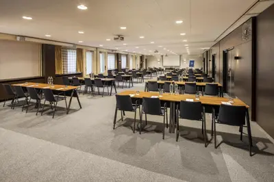 a conference room with long tables and chairs at NH Amsterdam Leidseplein in Amsterdam
