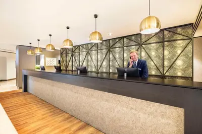 a man talking on a cell phone at a lobby counter at NH Amsterdam Leidseplein in Amsterdam