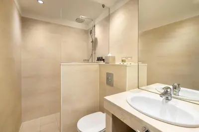 a bathroom with a sink and a toilet and a mirror at NH Amsterdam Leidseplein in Amsterdam