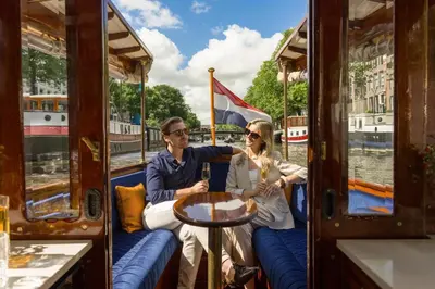 a man and a woman sitting on a boat at NH Collection Amsterdam Barbizon Palace in Amsterdam