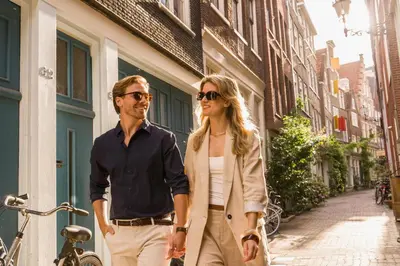 a man and a woman walking down a street at NH Collection Amsterdam Barbizon Palace in Amsterdam