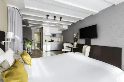 a bedroom with a large white bed with yellow pillows at NH Collection Amsterdam Barbizon Palace in Amsterdam