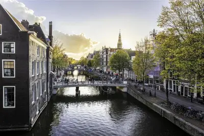 a river in a city with a bridge and buildings at NH Collection Amsterdam Barbizon Palace in Amsterdam
