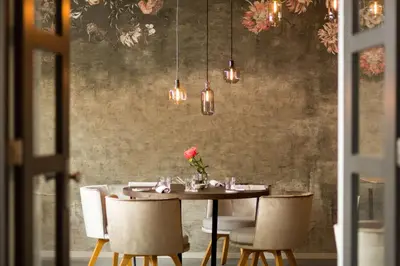 a dining room with a table with chairs and lights at NH Collection Amsterdam Barbizon Palace in Amsterdam