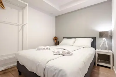 a white bedroom with a large bed with towels on it at Summer House in Zandvoort