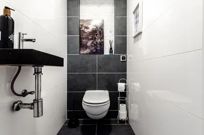 a bathroom with a white toilet and a sink at Summer House in Zandvoort