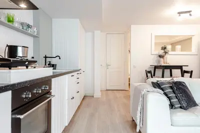 a white kitchen with a white couch in a room at Summer House in Zandvoort
