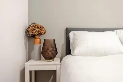 a bedroom with a bed and a table with a vase on it at Summer House in Zandvoort
