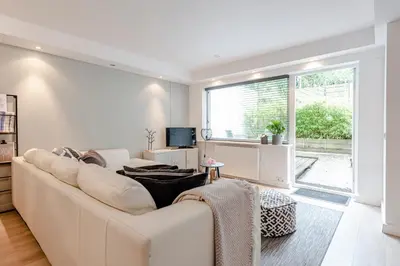 a white living room with a white couch and a window at Summer House in Zandvoort
