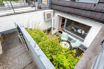 an overhead view of a backyard with chairs and a dog in a window at Summer House in Zandvoort