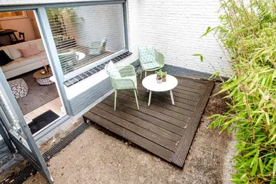 a patio with two chairs and a table on a porch at Summer House in Zandvoort