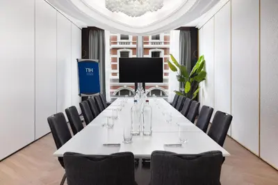 a conference room with a long table and chairs at NH Amsterdam Caransa in Amsterdam