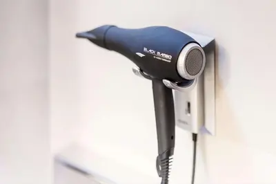a hair dryer is attached to a wall at NH Amsterdam Caransa in Amsterdam