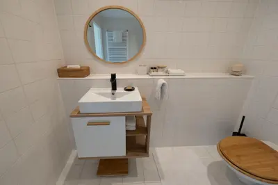 a white bathroom with a sink and a mirror at Canal View Stay Amsterdam in Amsterdam