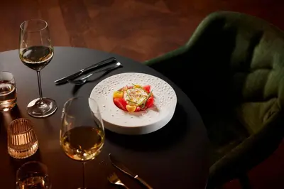 a plate of food on a table with wine glasses at Tivoli Doelen Amsterdam Hotel in Amsterdam