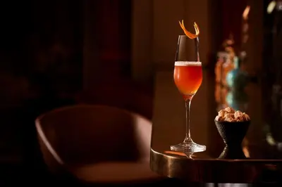 a glass of wine and a small bowl of popcorn at Tivoli Doelen Amsterdam Hotel in Amsterdam