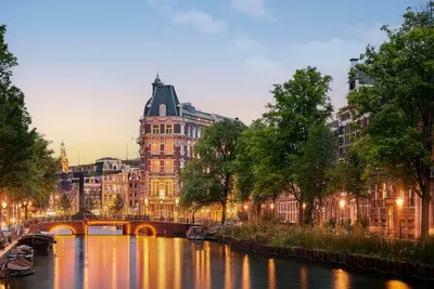 a bridge over a river in front of a building at Tivoli Doelen Amsterdam Hotel in Amsterdam