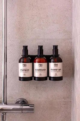 a shelf with four bottles of fire antiments on it at NH Amsterdam Schiller in Amsterdam