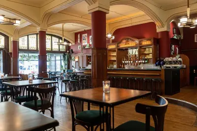 a restaurant with tables and chairs and a bar at NH Amsterdam Schiller in Amsterdam