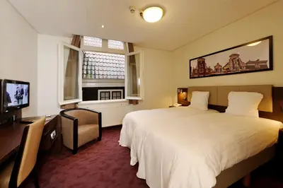 a bedroom with a large white bed and a television at Best Western Dam Square Inn in Amsterdam
