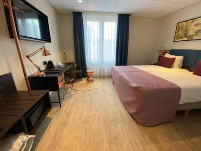 a hotel room with a bed and a desk and a desk at Best Western Dam Square Inn in Amsterdam
