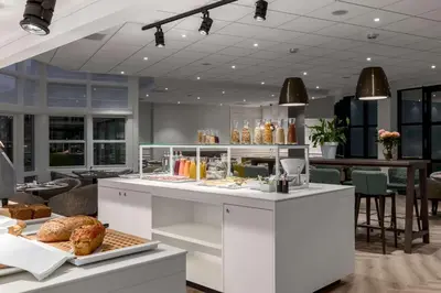 a bakery with a counter with food on it at NH Bussum Jan Tabak in Bussum
