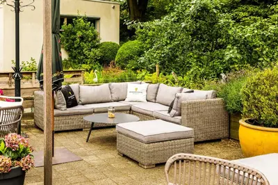 a patio with a couch and a table and chairs at NH Bussum Jan Tabak in Bussum