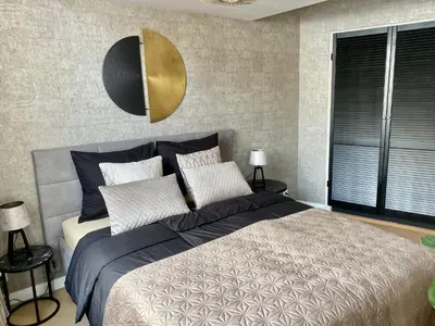 a bedroom with a large bed with blue and white pillows at Glücklich am Meer Suite Deluxe mit Wellnesszugang in Egmond aan Zee