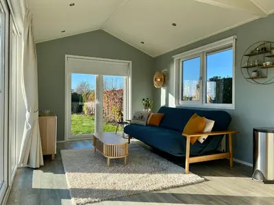 a living room with a blue couch and windows at New - Waterfont Villa08 - Private Residence on a lake near Amsterdam in Vinkeveen