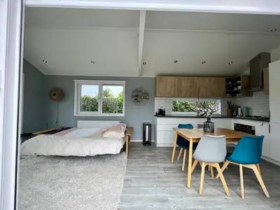 a bedroom with a bed and a table and chairs at New - Waterfont Villa08 - Private Residence on a lake near Amsterdam in Vinkeveen