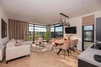 a living room with a table and a dining room at MarinaPark Residentie Nieuw Loosdrecht in Loosdrecht