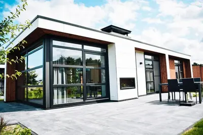 a house with large windows and a patio at MarinaPark Residentie Nieuw Loosdrecht in Loosdrecht