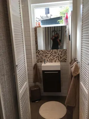 a person taking a picture of a bathroom mirror at Summerhouse Zandvoort in Zandvoort