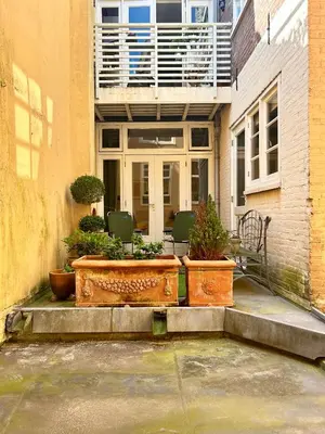 a building with a patio with chairs and plants at Leiden City Centre Canal View or Terrace View Apartments in Leiden