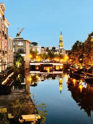 a bridge over a river in a city at night at Leiden City Centre Canal View or Terrace View Apartments in Leiden