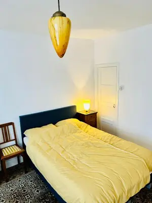 a bedroom with a bed with a yellow comforter at Leiden City Centre Canal View or Terrace View Apartments in Leiden