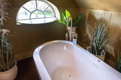 a bath tub in a bathroom with potted plants at The Butchersfarm in Ter Aar