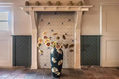 a large black and white vase with flowers on a wall at The Butchersfarm in Ter Aar