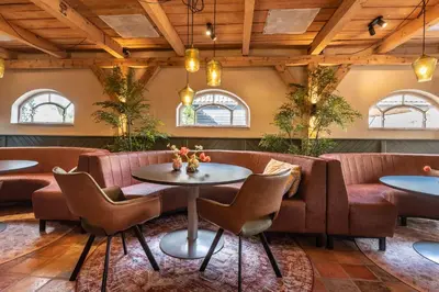 a restaurant with tables and chairs and windows at The Butchersfarm in Ter Aar