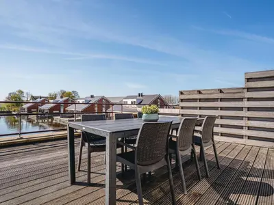 a table and chairs on the deck of a house at Apartment in Waterpark in Uitgeest in Uitgeest