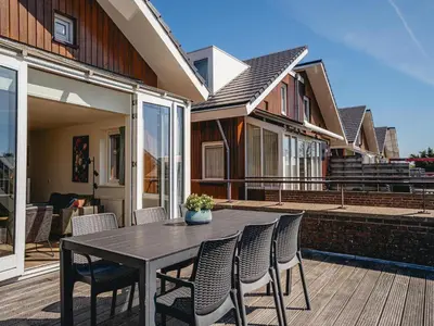 a black table and chairs on a patio with a house at Apartment in Waterpark in Uitgeest in Uitgeest