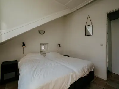 a bedroom with a large white bed in a room at Apartment in Waterpark in Uitgeest in Uitgeest