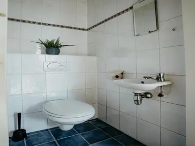 a white bathroom with a toilet and a sink at Apartment in Waterpark in Uitgeest in Uitgeest