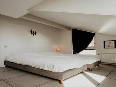 a bedroom with a large bed in a room at Houseboat in Waterpark with Private Dock in Uitgeest