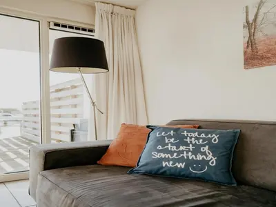 a couch with a pillow that says just something new at Houseboat in Waterpark with Private Dock in Uitgeest
