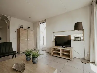 a living room with a flat screen tv and a couch at Houseboat in Waterpark with Private Dock in Uitgeest