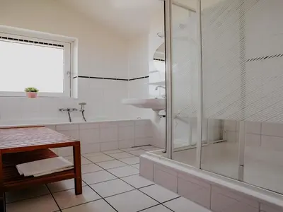 a white bathroom with a shower and a sink at Apartment in Waterpark with Private Jetty in Uitgeest