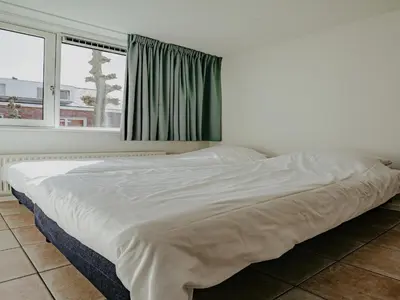 a white bed in a room with a window at Apartment in Waterpark with Private Jetty in Uitgeest