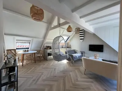 a living room with a couch and a table at Loft met zeezicht in Egmond aan Zee